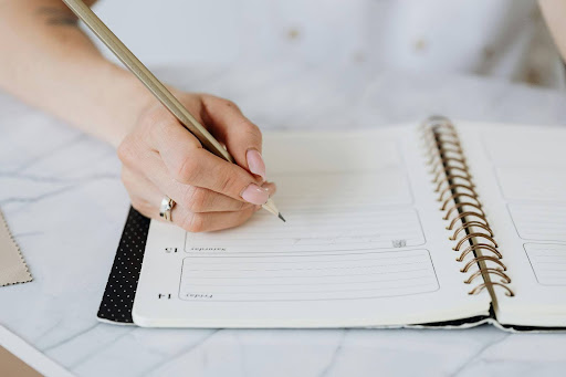 woman writing in her daily planner journal
