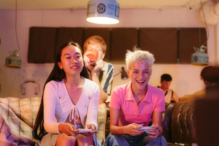 A group of teens playing video games and having fun indoors, showcasing joy and friendship.